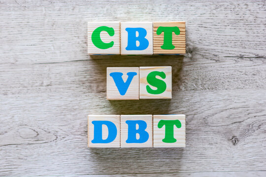 Text CBT vs DBT on wooden cubes with colorful letters on wooden background
