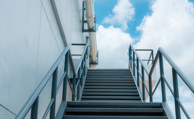 Fototapeta premium Industrial metal staircase with blue sky.