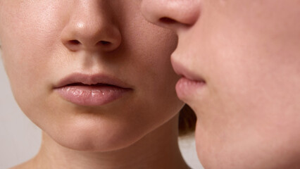 Obraz premium Close focus on lips of red-haired woman with blond man leaning near in tender portrait. Concept of skincare minimalism, self-care aesthetics, editorial content, and wellness campaigns.