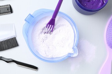 Hair care product for blonde hair and hairdresser's tools on white background, flat lay