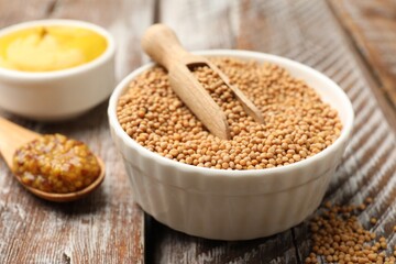 Different types of mustard on wooden table, closeup