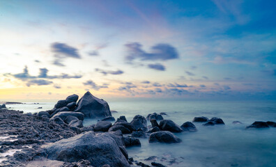 Rocky coastline along the seashore of Aruba with ocean, rocks and sunset