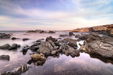 Rocky coastline along the seashore of Aruba with ocean, rocks and sunset