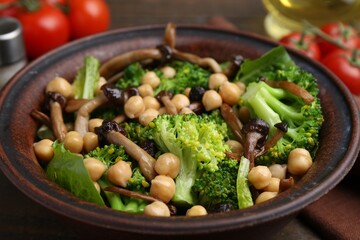 Delicious salad with shimeji mushrooms, chickpeas and broccoli in bowl on table, closeup