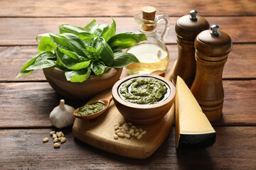 Fresh pesto sauce and ingredients on wooden table, closeup