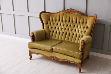 Stylish sofa near gray wall in room