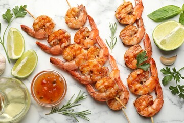 Skewers with tasty grilled shrimps, lime slices, herbs, oil and sauce on white marble table, flat lay. Delicious seafood dish
