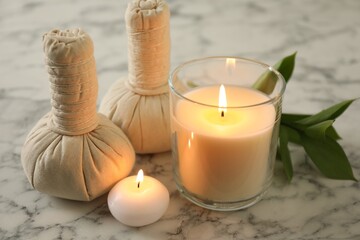 Beautiful spa composition with burning candles on white marble table, closeup