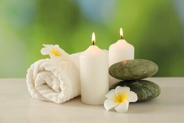 Beautiful spa composition with burning candles on white wooden table against blurred background, closeup