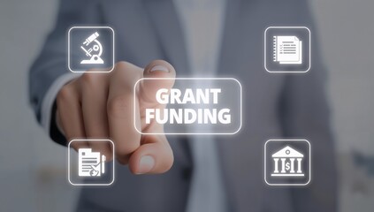 Man using virtual touchscreen presses inscription: GRANT FUNDING. Concept of business, education grants funding