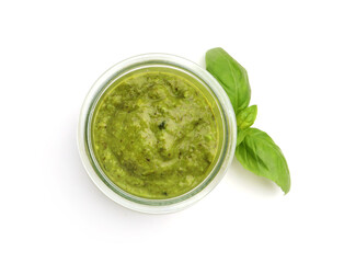 Pesto sauce in jar and fresh basil leaves isolated on white, top view