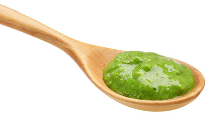 Fresh pesto sauce in wooden spoon isolated on white