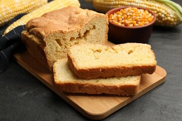 Freshly baked cornbread, cobs and seeds on black table, closeup