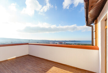 A balcony overlooking a city with a view of the ocean
