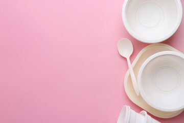 Set of disposable plastic tableware on pink background, flat lay. Space for text
