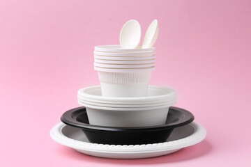 Set of disposable plastic tableware on pink background, closeup