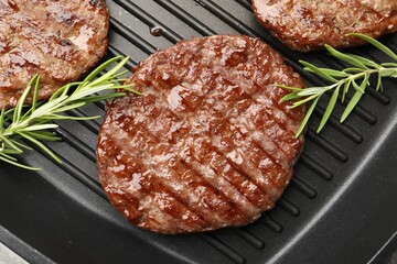 Pan with grilled patties and rosemary, top view