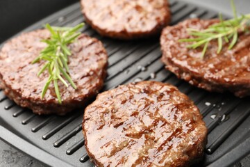 Pan with grilled patties and rosemary, closeup