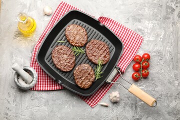 Pan with grilled patties, tomatoes and spices on grey table, flat lay