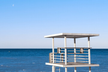 Beautiful view of wavy sea and lifeguard tower on sunny day