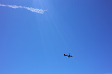 Airplane flying in beautiful blue sky, bottom view