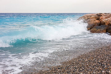 Beautiful view of wavy sea and pebbles on beach