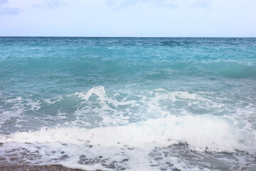 Beautiful view of wavy sea and pebbles on beach
