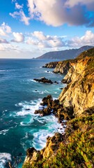 Fototapeta premium Dramatic coastal view; cliffs meet turquoise ocean under a partly cloudy sky