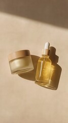 A minimalist composition featuring a glass dropper bottle and a jar of golden liquid against a warm, textured background with soft shadows.