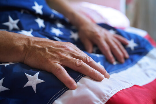 Veteran hand resting on American flag symbolizing patriotism and honor