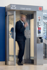 A man in suit passes through the security entrance for airport personnel