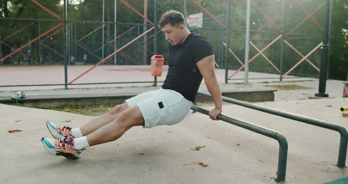 Engaging in an Intense Workout Session Utilizing Parallel Bars at the Park Facility