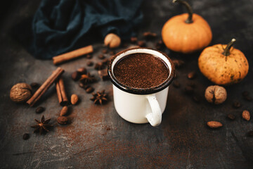 Mug of hot chocolate, pumpkins and spices on rustic background, cozy autumn scene
