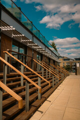 Obraz premium Modern Riverside Building with Wooden Steps and Glass Balustrade