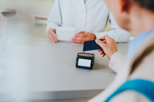 Customer making payment by credit card at pharmacy counter