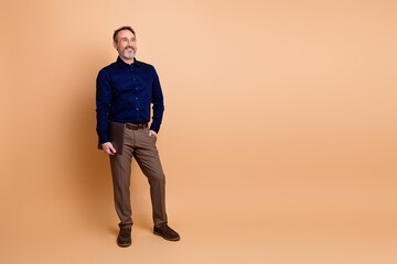 Fototapeta premium Confident businessman standing with a professional attire on beige background in studio