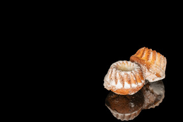 Sweet homemade cupcakes isolated on black background, close-up.