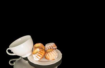Sweet homemade cupcakes isolated on black background, close-up.