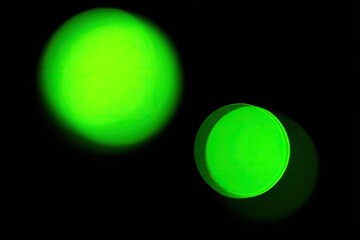 Two bright, vibrant green circles against a black background