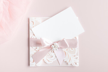 White wedding luxury invitation card mockup 7x5 on pastel pink background with envelop. Baby shower o bridal shower mockup. Minimal style blank mockup, thank you card, greeting card