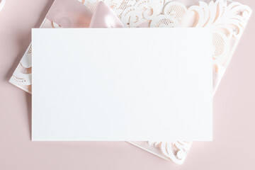 White wedding luxury invitation card mockup 7x5 on pastel pink background with envelop and flavor. Baby shower o bridal shower mockup. Minimal style blank mockup, thank you card, greeting card