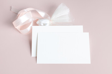 Wedding stationery invitation card mockup 7x5 on pastel pink background with envelop and flavor. Baby shower o bridal shower mockup. Minimal style blank mockup, thank you card, greeting card