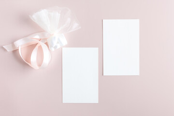 Two Blank wedding invitation stationery card mockup with favor on pastel pink background, feminine blog. Valentines day card, valentines day background, mothers day. Minimalist mockup 5x7 ratio