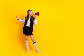 Fototapeta premium Cheerful Female Student Using Megaphone on Bold Yellow Background Highlighting Energy and Educational Youth Lifestyle
