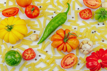 Raw mafalda corta pasta with assorted heirloom tomatoes, garlic, chili pepper, and spices