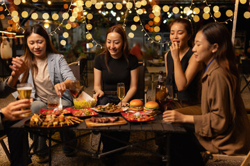 Happy Friends Celebrating Together at Night, Young Asian Group of Friends Having Fun and Toasting Drinks Outdoors At Night, Enjoying a Celebration Concept.