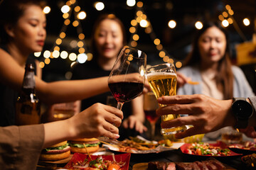 Happy Friends Celebrating Together at Night, Young Asian Group of Friends Having Fun and Toasting Drinks Outdoors At Night, Enjoying a Celebration Concept.