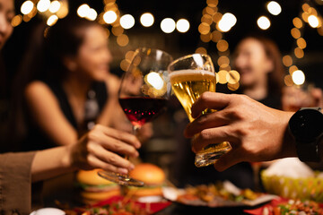 Happy Friends Celebrating Together at Night, Young Asian Group of Friends Having Fun and Toasting Drinks Outdoors At Night, Enjoying a Celebration Concept.