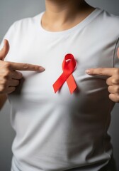 Woman pointing at red ribbon on white tshirt for world aids day campaign