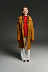 Stylish preteen girl showcases trendy winter fashion in studio setting
